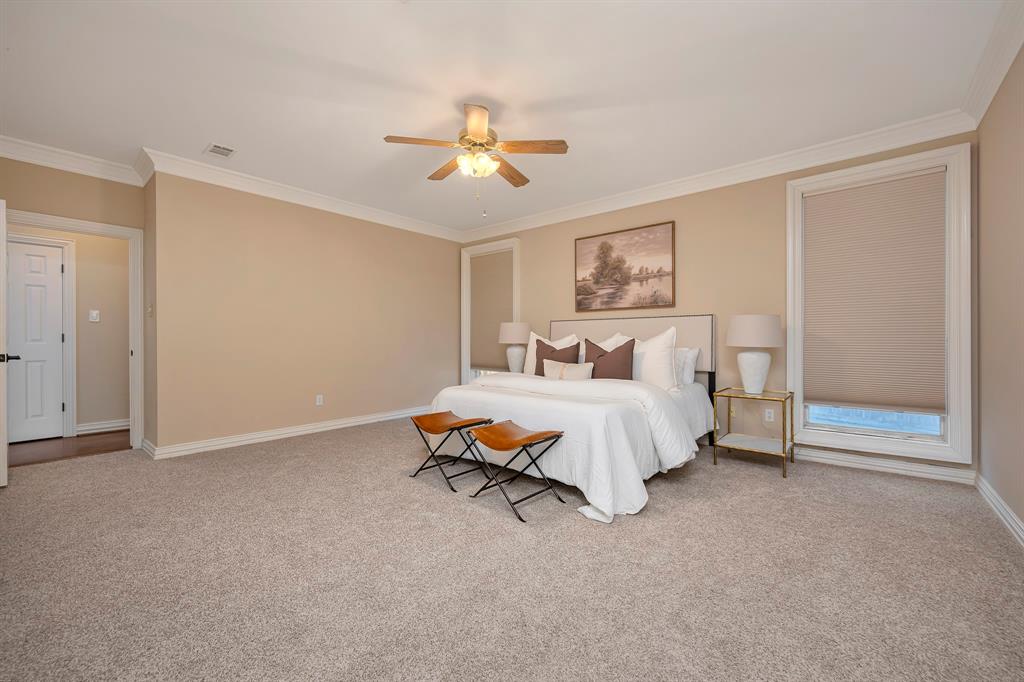 4008 Ramsgate Court Colleyville, TX 76034 - Photo 3 of 33 Spacious bedroom featuring plush carpeting, a ceiling fan, crown molding, and a large window with roller shades