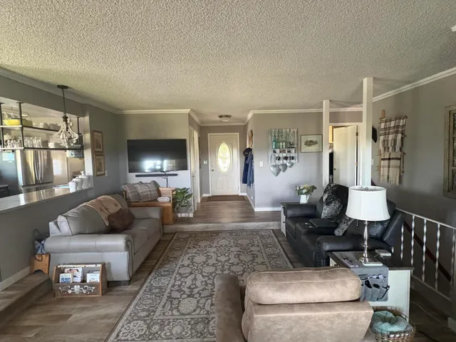 a living room with furniture wooden floor and a floor to ceiling window