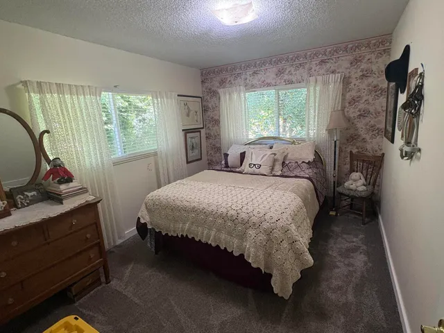 a bedroom with a bed and a large window