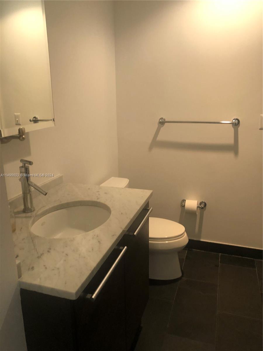 900 Biscayne Boulevard, Unit 4904 Miami, FL 33132 - Photo 15 of 29 a bathroom with a granite countertop sink and a toilet