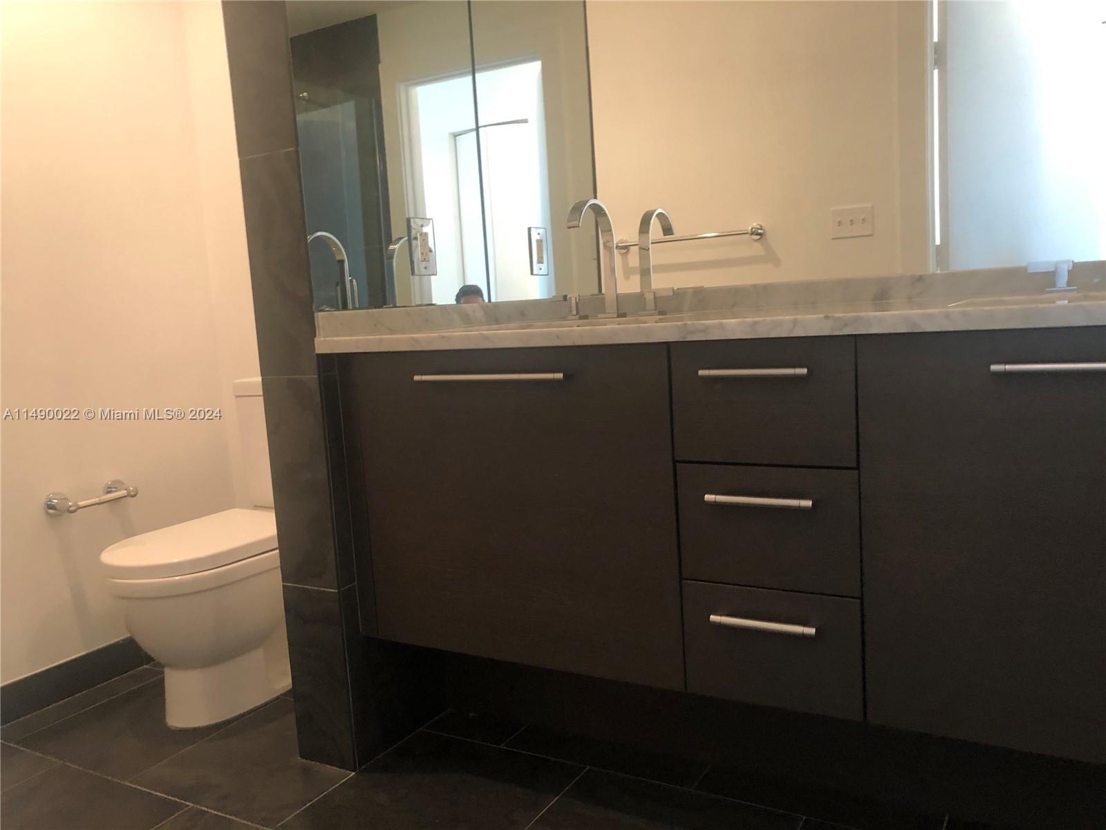 900 Biscayne Boulevard, Unit 4904 Miami, FL 33132 - Photo 8 of 29 a bathroom with a granite countertop sink a toilet and a window