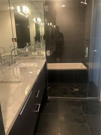 a bathroom with a sink a mirror and shower