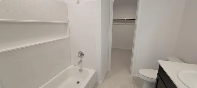 a white toilet sitting next to a bath tub
