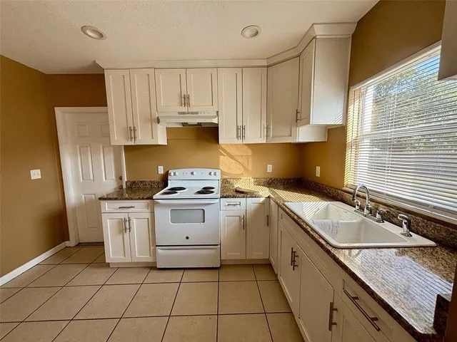 a kitchen with a stove sink and cabinets