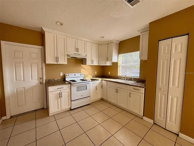 a kitchen with a stove top oven and cabinets