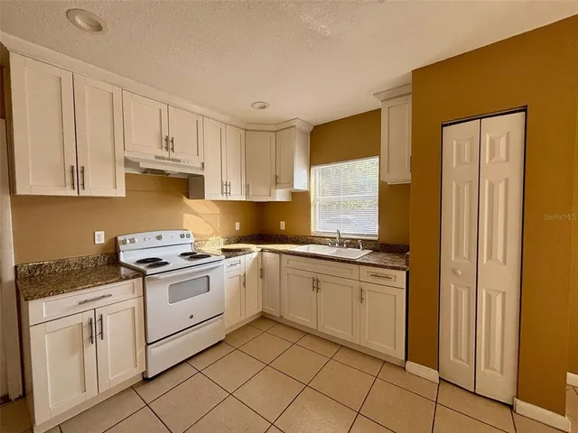 a kitchen with cabinets appliances and a window