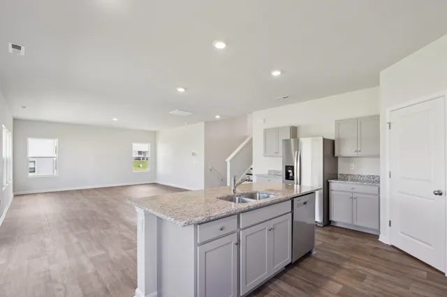a bathroom with a granite countertop sink and a refrigerator