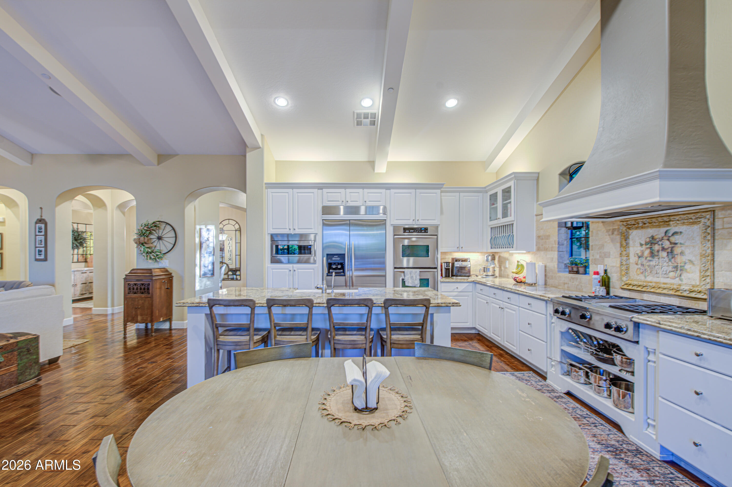 14474 West Coronado Road Goodyear, AZ 85395 - Photo 34 of 74 a kitchen with stainless steel appliances kitchen island granite countertop a stove a sink a dining table and chairs