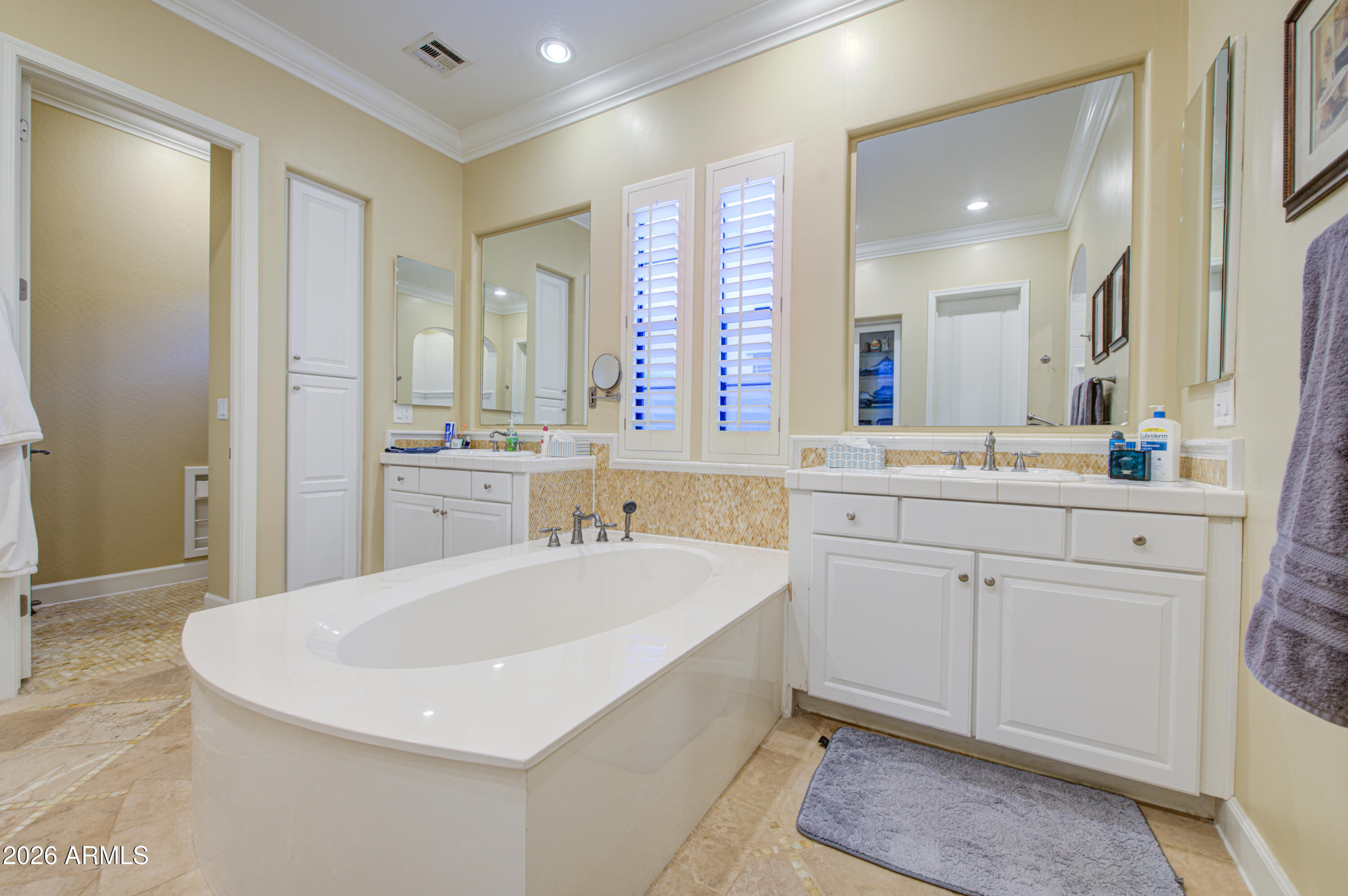14474 West Coronado Road Goodyear, AZ 85395 - Photo 54 of 74 a bathroom with a sink a large mirror and a bathtub