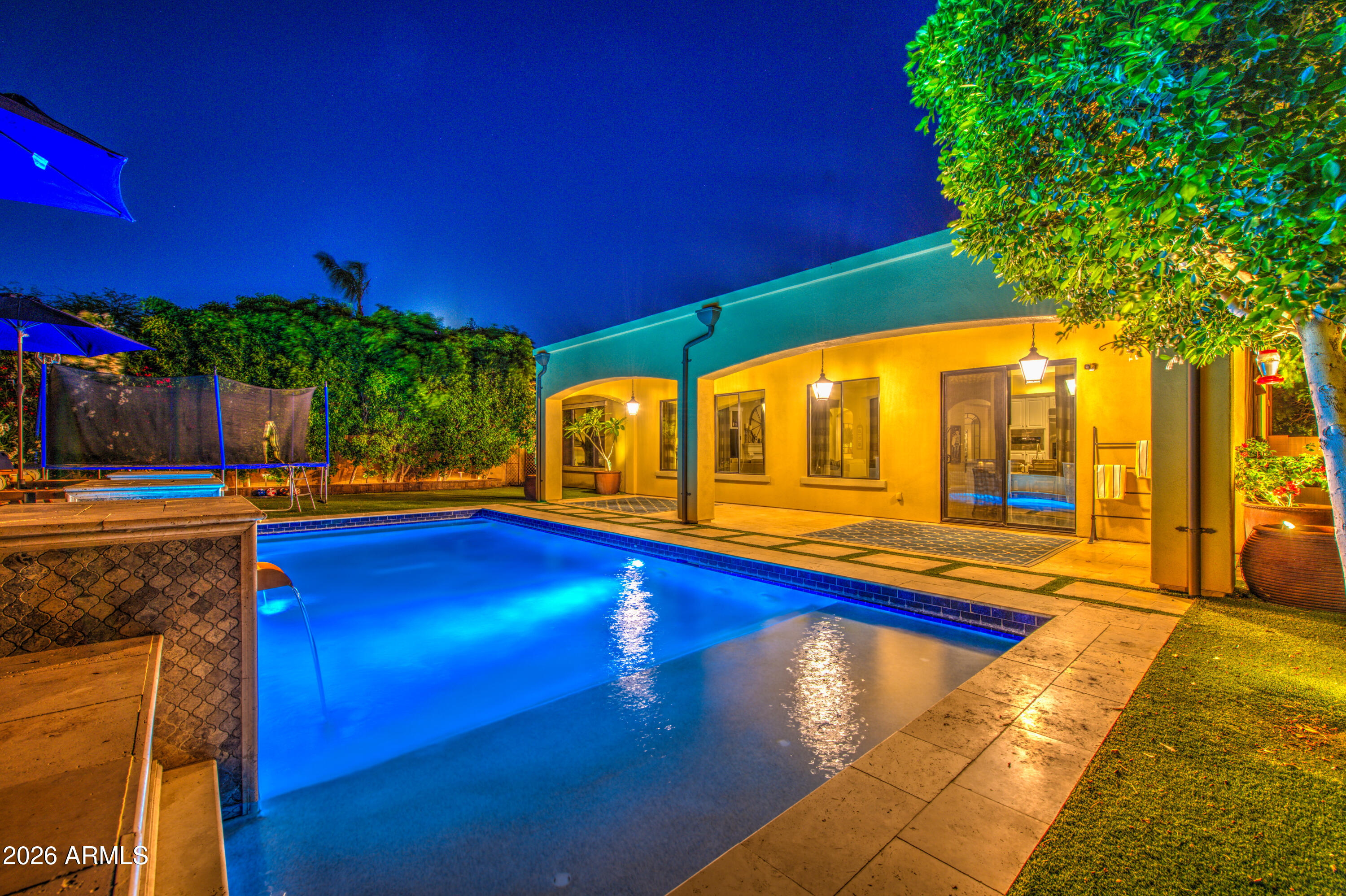 14474 West Coronado Road Goodyear, AZ 85395 - Photo 66 of 74 a view of swimming pool with lawn chairs under an umbrella