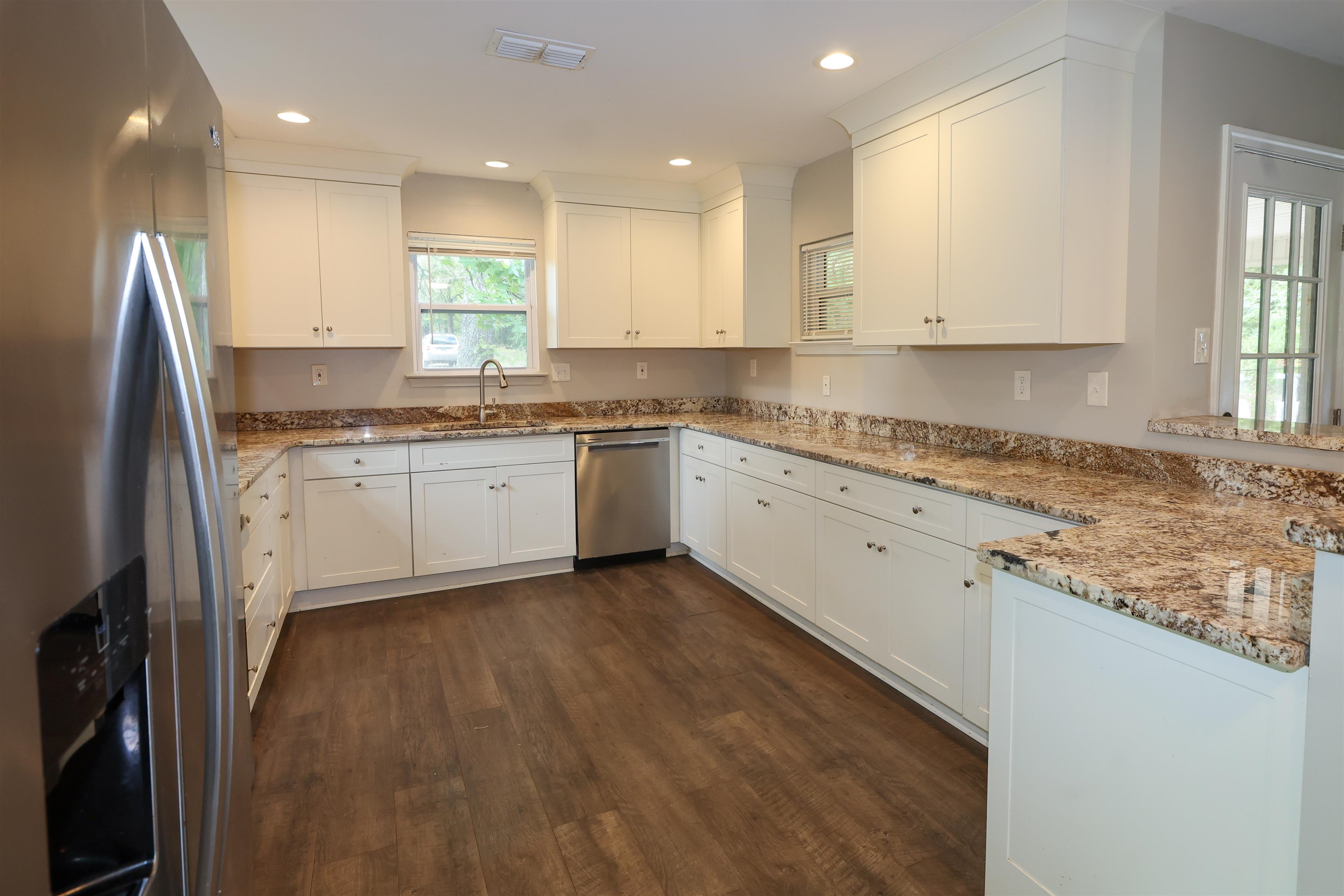 8074 Van Road Arlington, TN 38002 - Photo 7 of 24 a large kitchen with granite countertop a sink a stove a refrigerator and white cabinets
