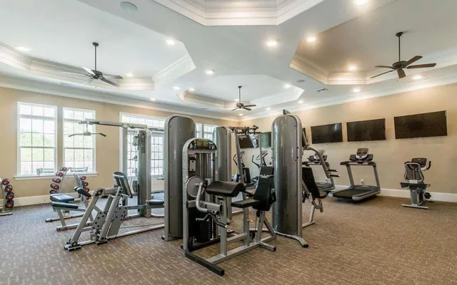 a living room with stainless steel appliances furniture and a flat screen tv