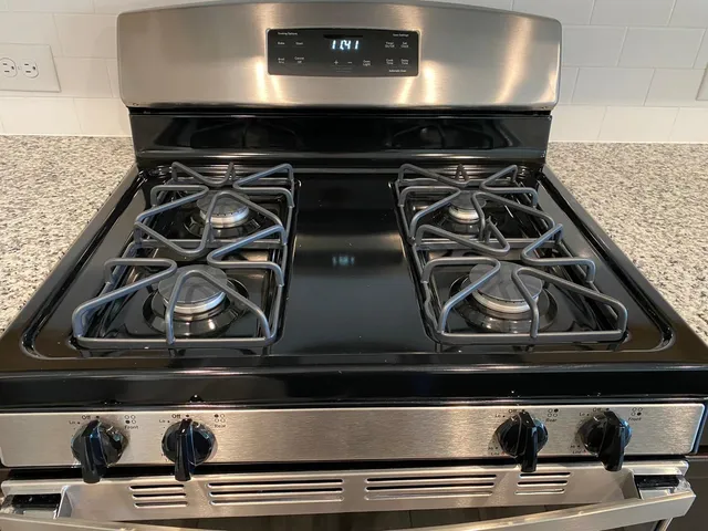 a kitchen with granite countertop a stove top oven and cabinets