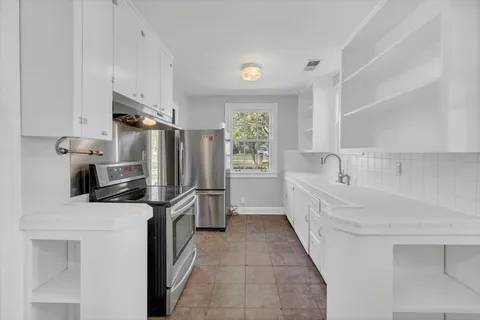 a kitchen with stainless steel appliances a refrigerator sink and microwave