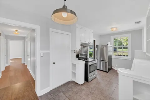 a kitchen with white cabinets and stainless steel appliances