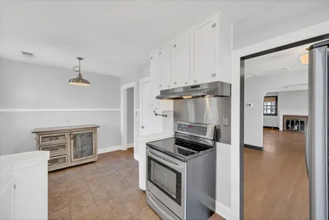 a kitchen with a refrigerator and a stove top oven