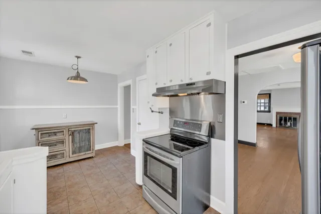 a kitchen with a refrigerator and a stove top oven
