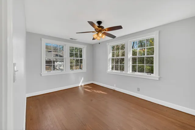 a view of wooden floor and a chandelier fan in a room