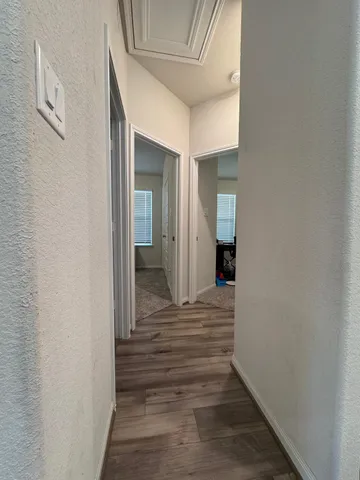 a view of a hallway with wooden floor and staircase