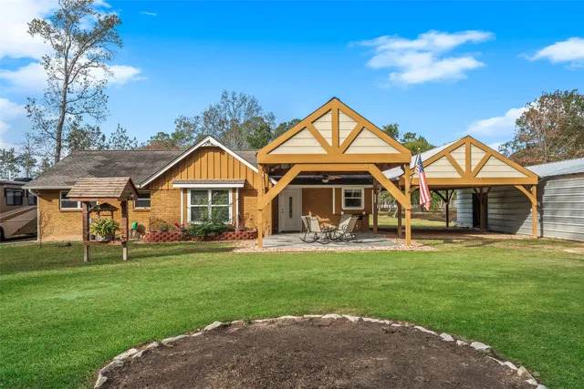a front view of a house with a garden and trees