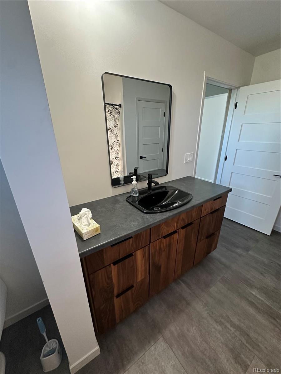 99 Cedar Ridge Road Mosca, CO 81146 - Photo 21 of 36 a room with wooden floor and cabinets