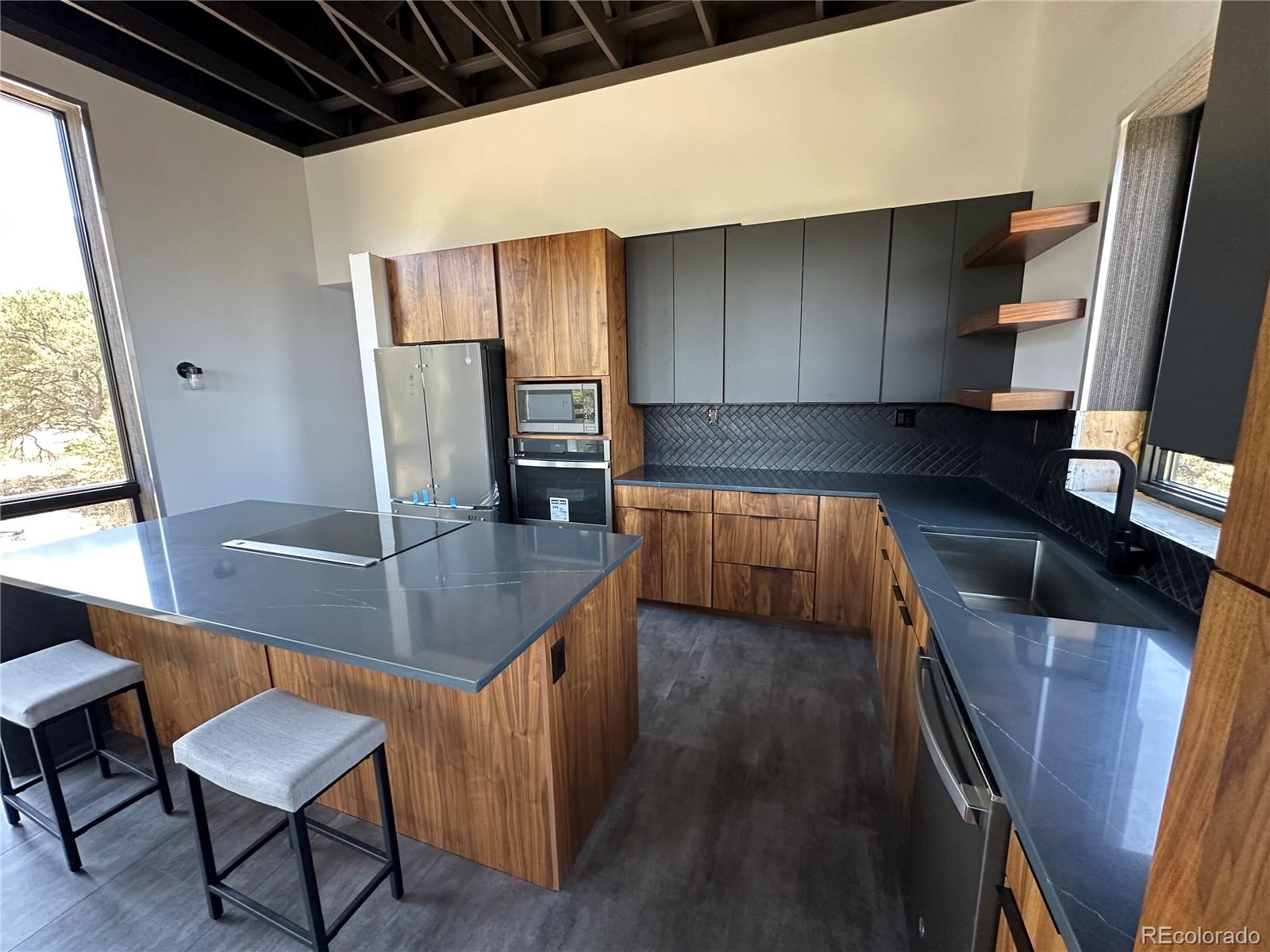 99 Cedar Ridge Road Mosca, CO 81146 - Photo 9 of 36 a kitchen with stainless steel appliances granite countertop a refrigerator a stove a sink dishwasher and cabinets with wooden floor