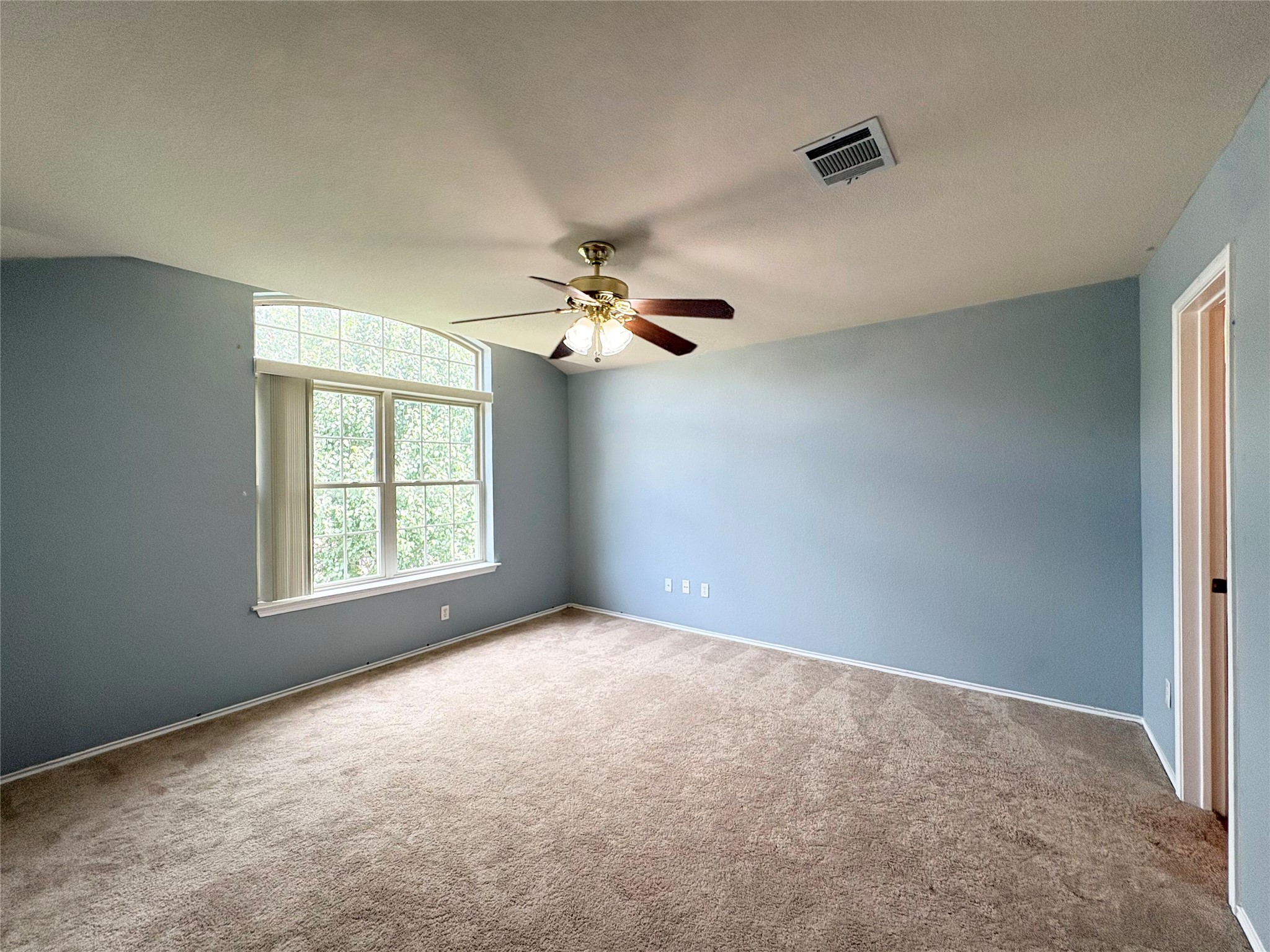 8103 Ephraim Road Austin, TX 78717 - Photo 20 of 35 A well-lit bedroom with soft carpet flooring and a prominent arched window.