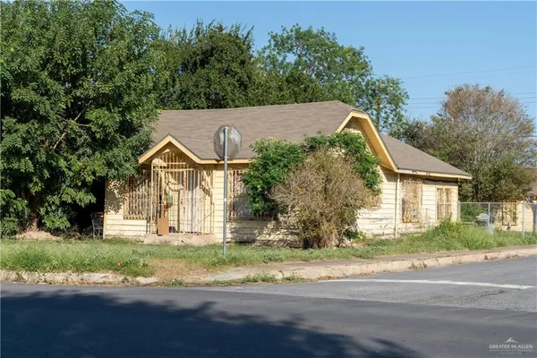 a view of a yard in front of a house with large trees