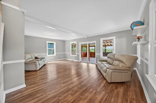a view of a livingroom with furniture wooden floor and windows