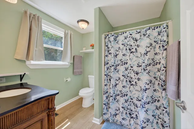 a view of an empty room with closet and wooden floor