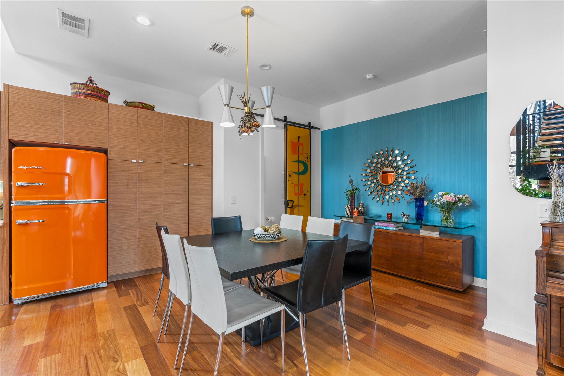 408 Starlight Village Loop Leander, TX 78641 - Photo 12 of 40 Hardwood flooring flows through this vibrant dining space, complemented by a contemporary light fixture and custom cabinetry.