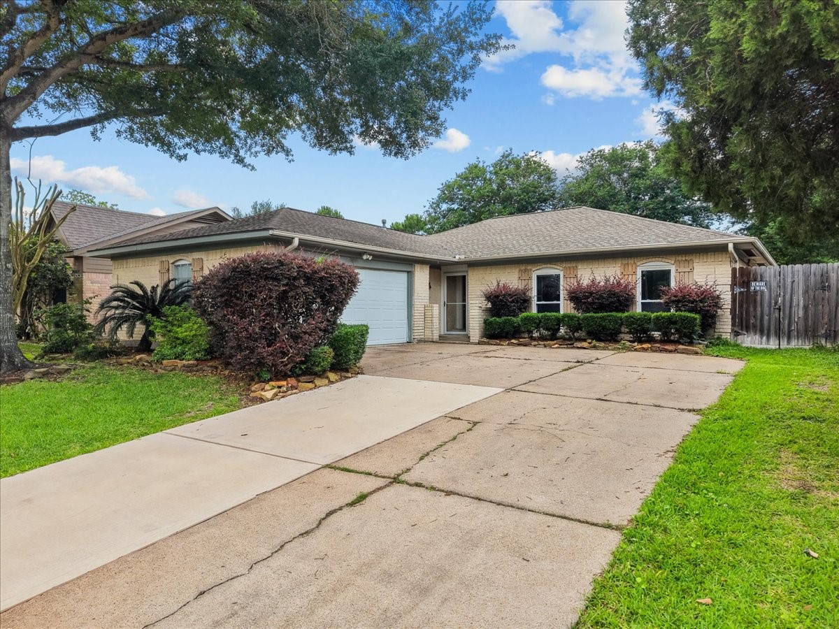 883 Silverpines Road Houston, TX 77062 - Photo 37 of 38 Charming single-story home with a two-car garage, well-maintained front yard, and mature landscaping. Features a spacious driveway, brick exterior, and a welcoming entrance.