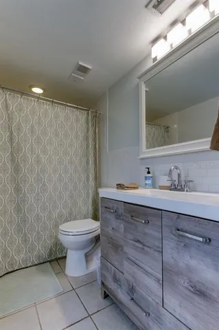 a bathroom with a sink toilet vanity and shower