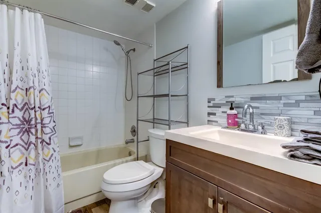 a view of a building in front of a big yard with large trees