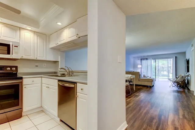 a kitchen with a sink a stove top oven and cabinets