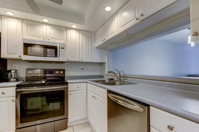 a kitchen with stainless steel appliances granite countertop a stove microwave and sink