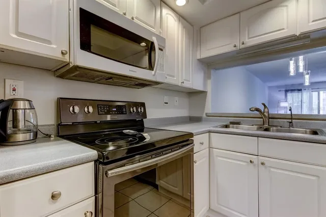 a kitchen with stainless steel appliances granite countertop a sink a stove and a refrigerator
