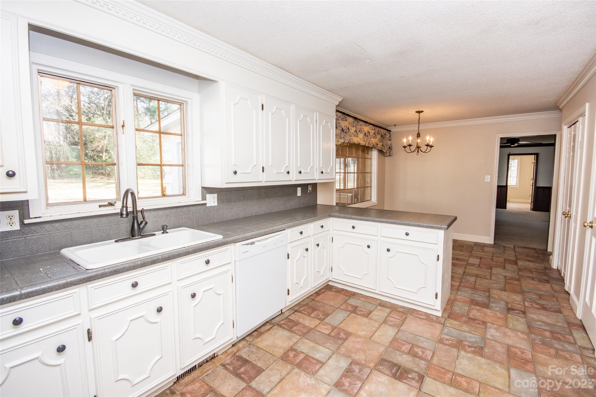 321 St Andrews Road Statesville, NC 28625 - Photo 5 of 19 a large white kitchen with granite countertop a sink white cabinets and a window