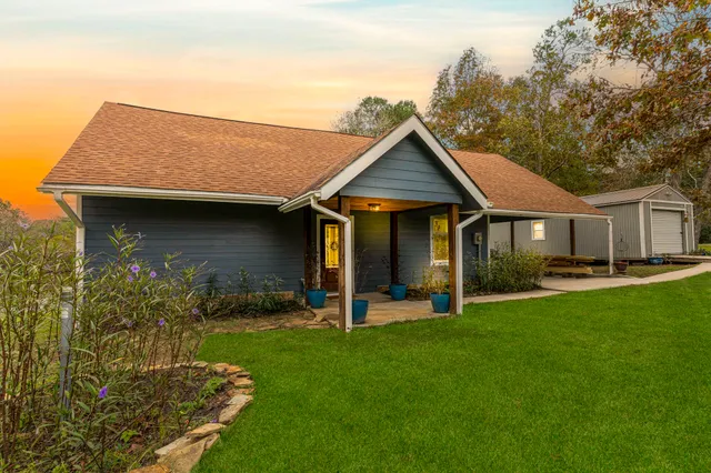 an aerial view of residential houses with outdoor space and trees