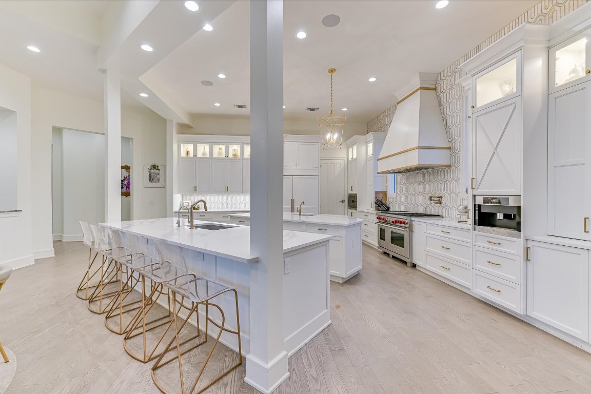 14132 Flat Top Ranch Road Austin, TX 78732 - Photo 14 of 40 a large white kitchen with lots of counter space a sink and appliances