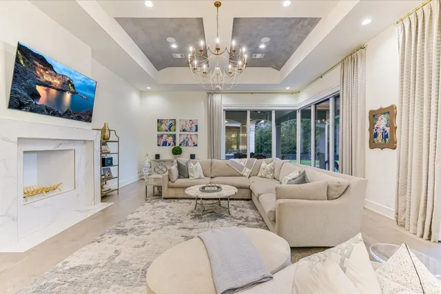 a living room with furniture a chandelier and a flat screen tv