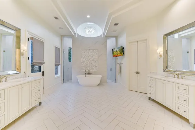 a spacious bathroom with a double vanity sink a mirror and a bathtub