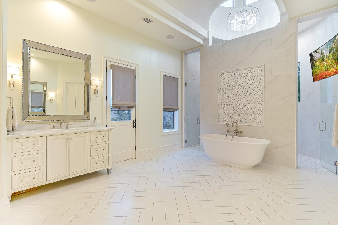 14132 Flat Top Ranch Road Austin, TX 78732 - Photo 22 of 40 a spacious bathroom with a double vanity sink and a mirror