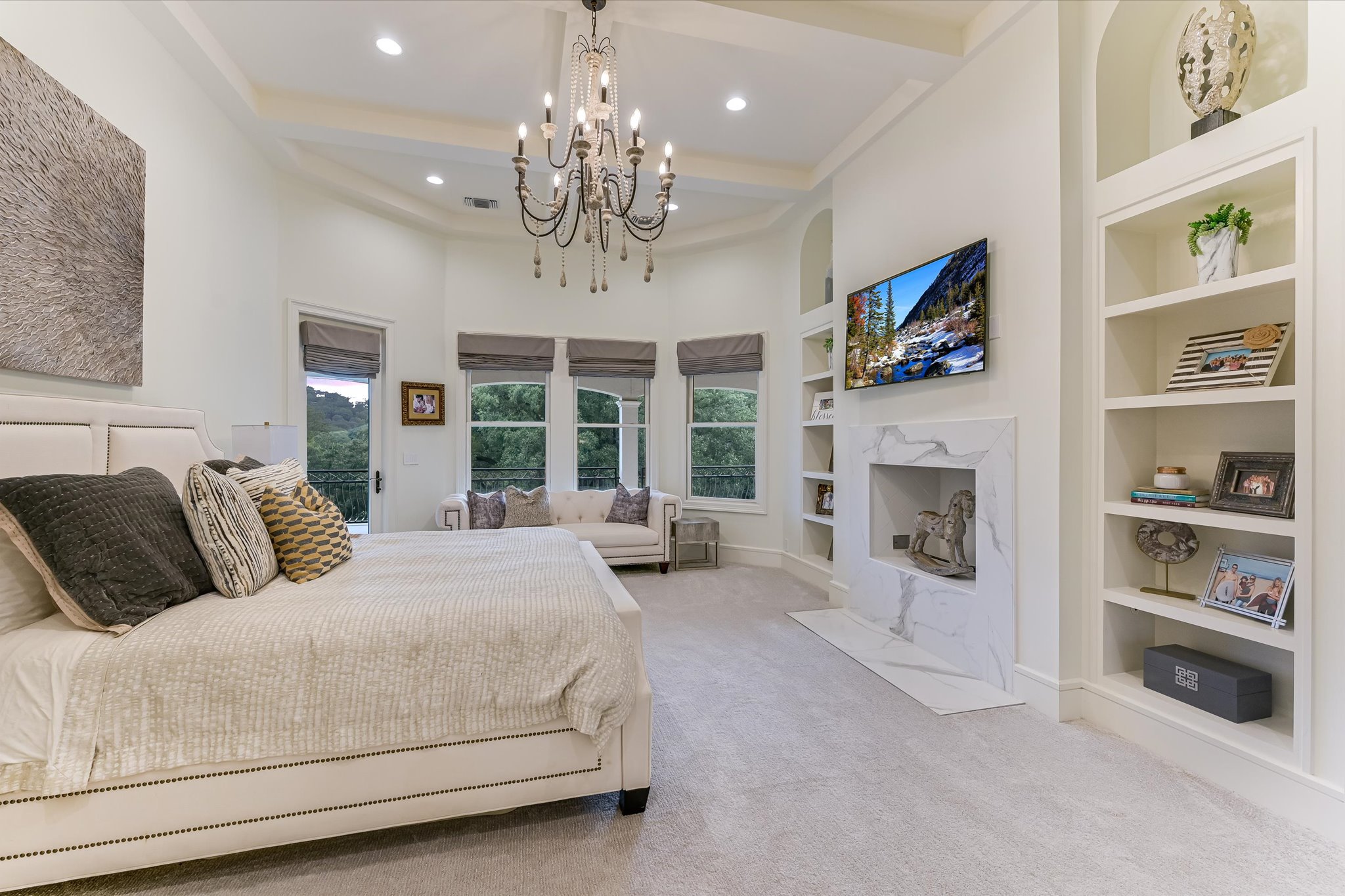 14132 Flat Top Ranch Road Austin, TX 78732 - Photo 26 of 40 a spacious bedroom with a large bed and a fireplace