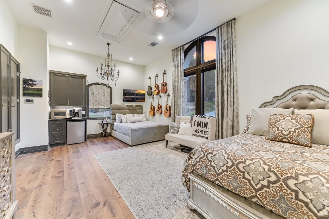 14132 Flat Top Ranch Road Austin, TX 78732 - Photo 30 of 40 a bedroom with a bed window and a television