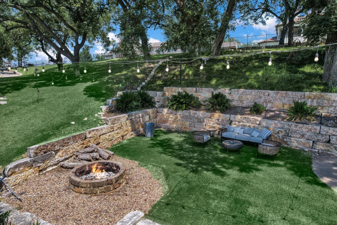 14132 Flat Top Ranch Road Austin, TX 78732 - Photo 39 of 40 a view of a backyard with table and chairs and a fire pit