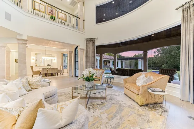 a living room with furniture a flat screen tv and floor to ceiling window