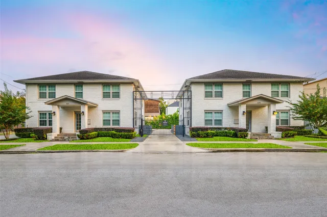 a front view of a house with a yard and trees