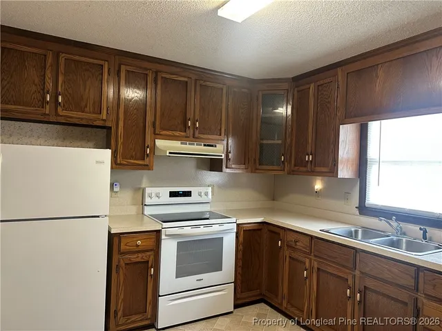 a kitchen with stainless steel appliances granite countertop a refrigerator sink and cabinets
