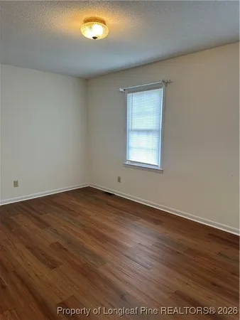 an empty room with wooden floor and a window